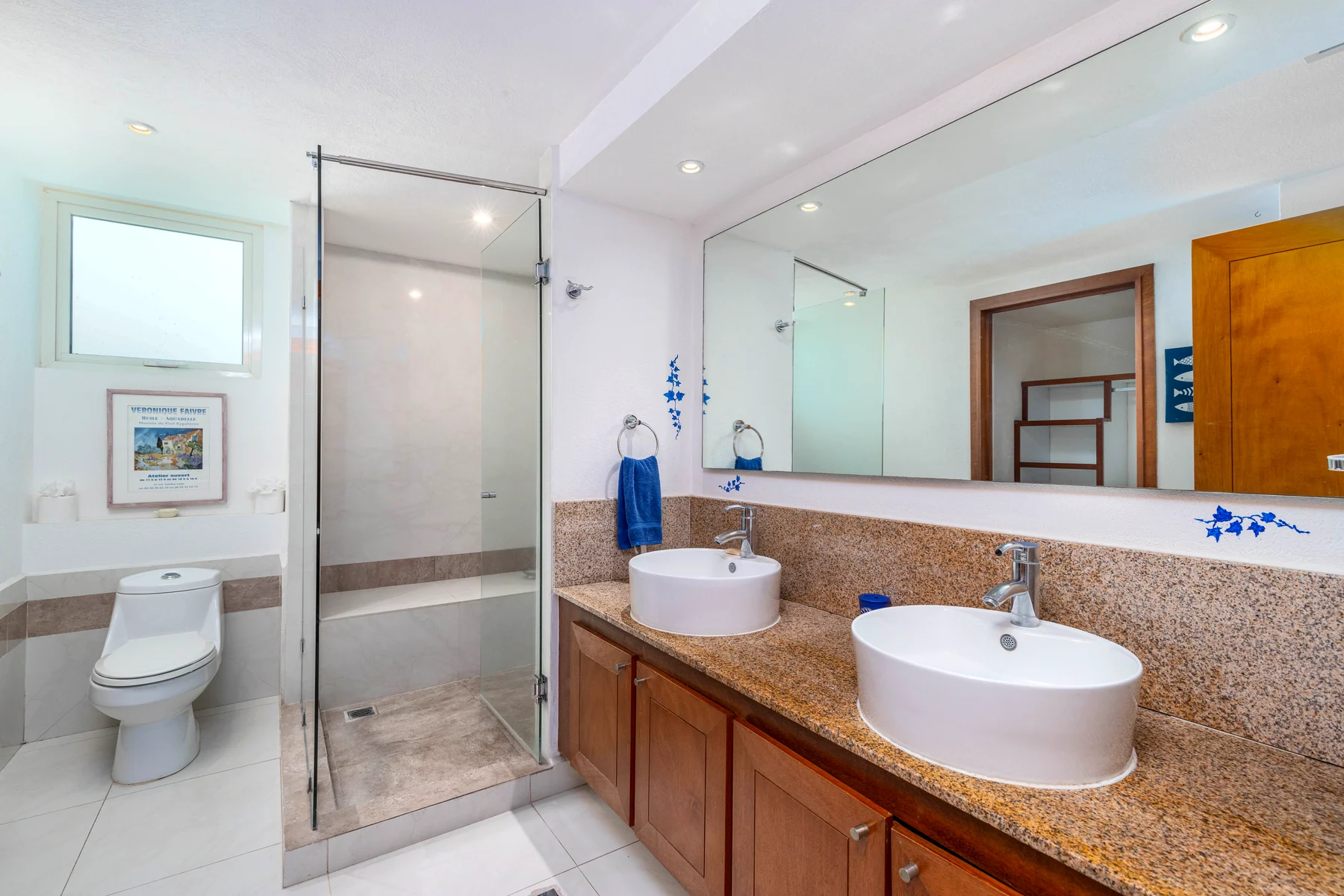 Primary bathroom with double stone vanity, tub and glass shower