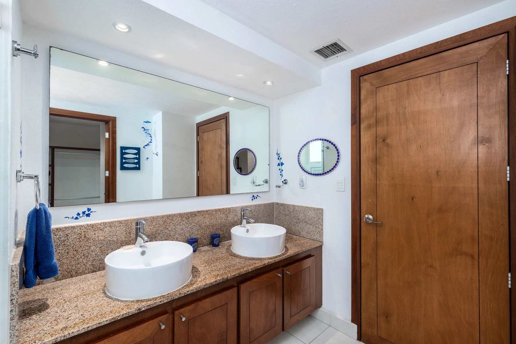Double vanity on a granite counter, with a wide mirror