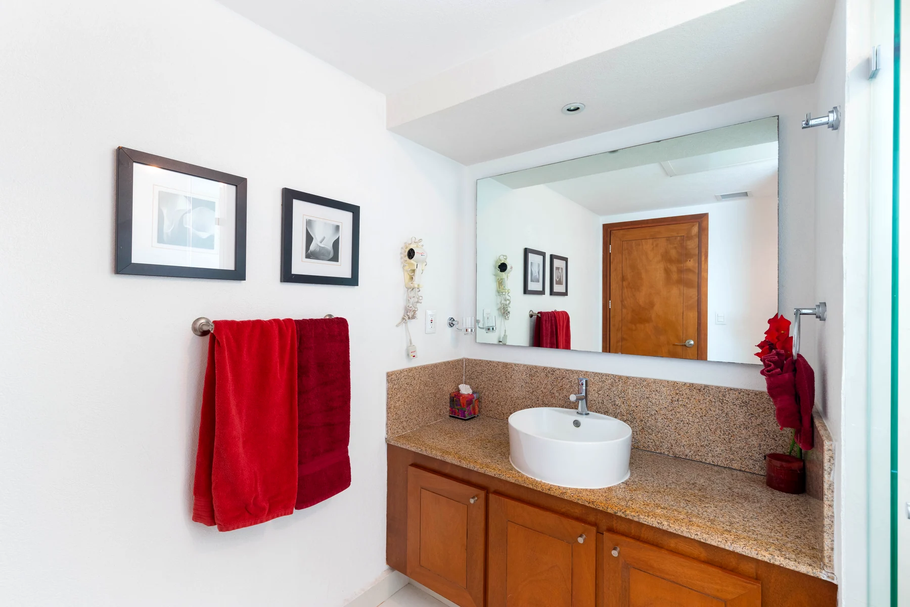 Bathroom with stone basin, wide mirror and fresh linens