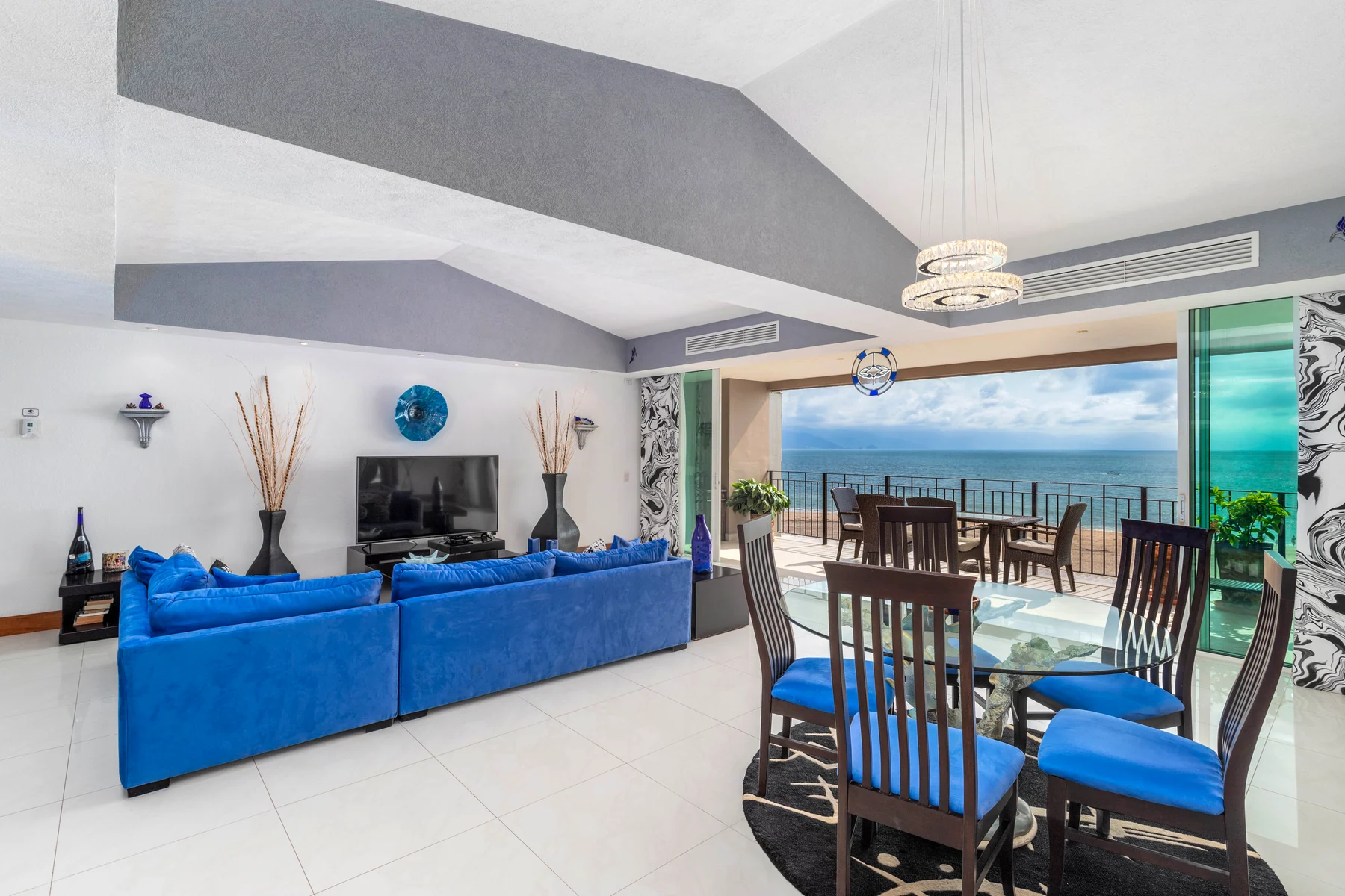 The living room of Residence 308, opening through a wall of glass onto the terrace and Banderas Bay