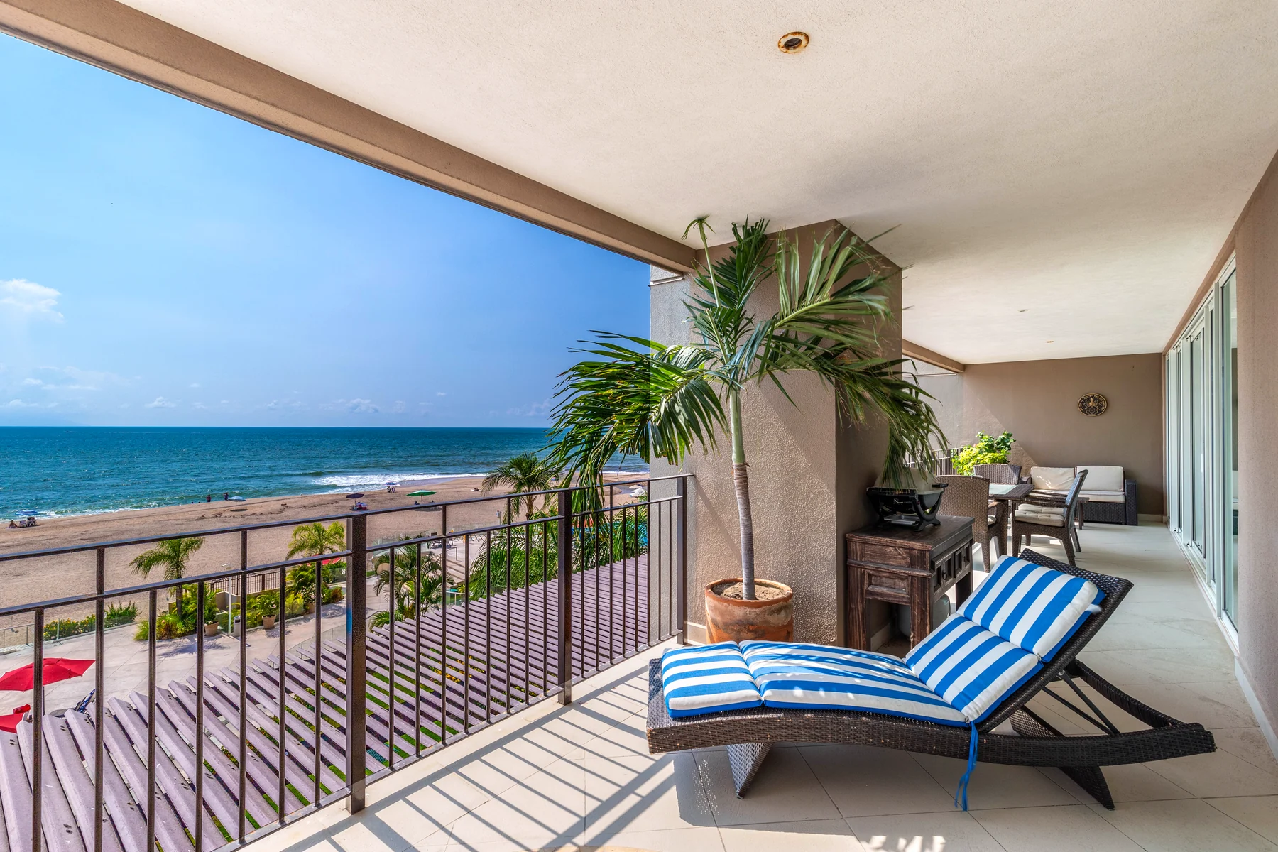 Private terrace with a lounger and a palm, open over the bay